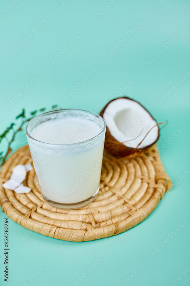 Fresh healthy coconut milk in a glass on blue background, Alternative type of vegan milks, Organic Healthy drink concept. Fresh healthy coconut milk in a glass on blue background, Alternative type of vegan milks, Organic Healthy drink concept.