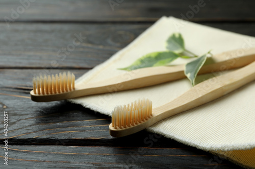 Napkin with eco friendly toothbrushes and twig on wooden background