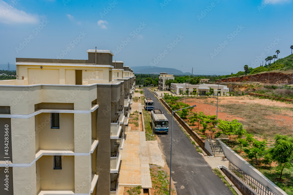 Top view of an Indian colony with bitumen road inside parking a bus, Building looking in line with pattern. Top view of an Indian colony with bitumen road inside parking a bus, Building looking in line with pattern.