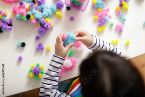 young girl playing creative building ball toy at home
