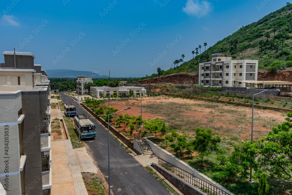 Top view of an Indian colony with bitumen road inside parking a bus, Building looking in line with pattern. Top view of an Indian colony with bitumen road inside parking a bus, Building looking in line with pattern.
