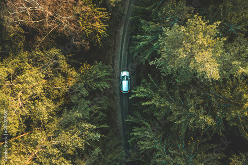 Aerial top down view of silver car driving in off-road way in the forest near Kaunas, Lithuania. photo