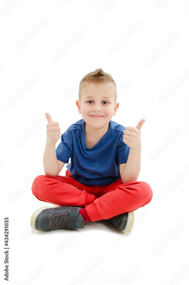Happy boy smiling and liking by pointing thumb fingers up, white sitting with cross legs. Isolated on white background
Happy boy smiling and liking by pointing thumb fingers up, white sitting with cross legs. Isolated on white background