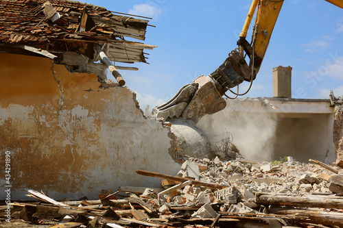 Tracked excavator demolishing old buildings