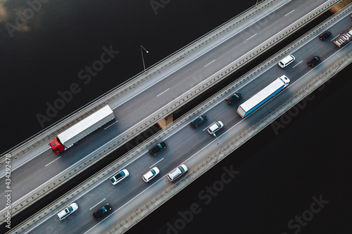 Aerial view of traffic vehicles driving on the highway bridge over the Neman river in Kaunas, Lithuania.