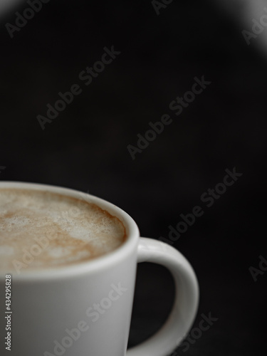 White coffee mug with coffee on black stone background
