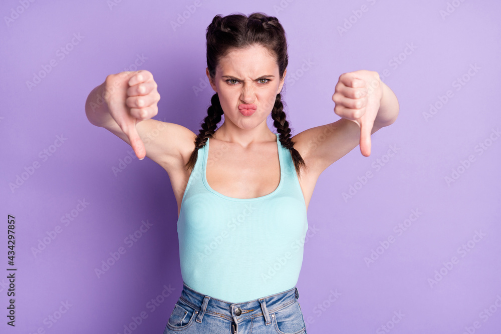 Portrait of attractive mad fury girl showing two double thumbs down isolated over violet purple color background Portrait of attractive mad fury girl showing two double thumbs down isolated over violet purple color background