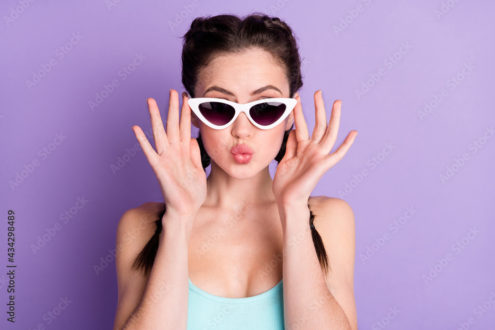 Photo portrait of young woman sending air kiss wearing sunglass isolated on pastel purple color background Photo portrait of young woman sending air kiss wearing sunglass isolated on pastel purple color background