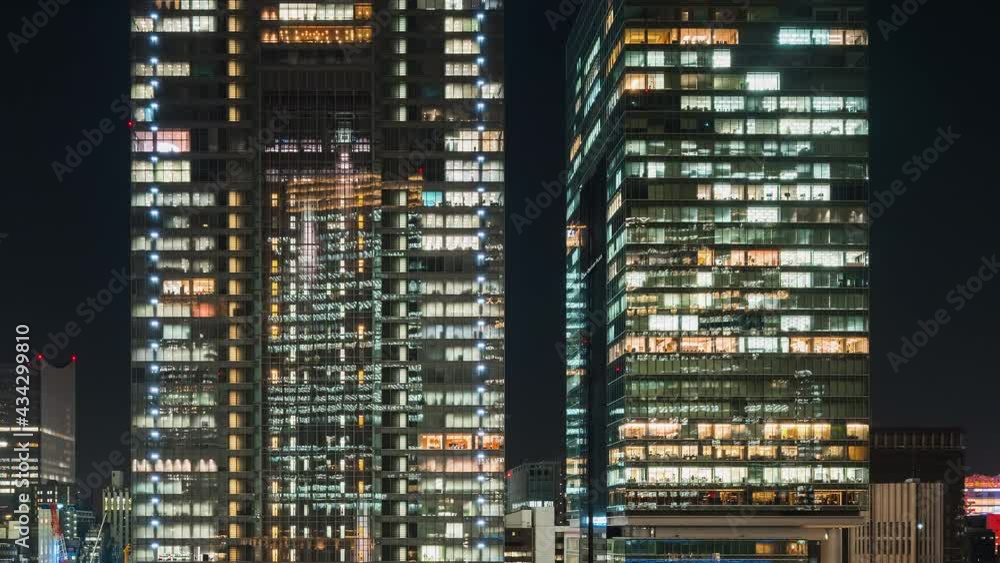 Time lapse of office building with elevator moving, people working, window facade view at night. Corporate business, office worker life, or building exterior architecture concept Time lapse of office building with elevator moving, people working, window facade view at night. Corporate business, office worker life, or building exterior architecture concept