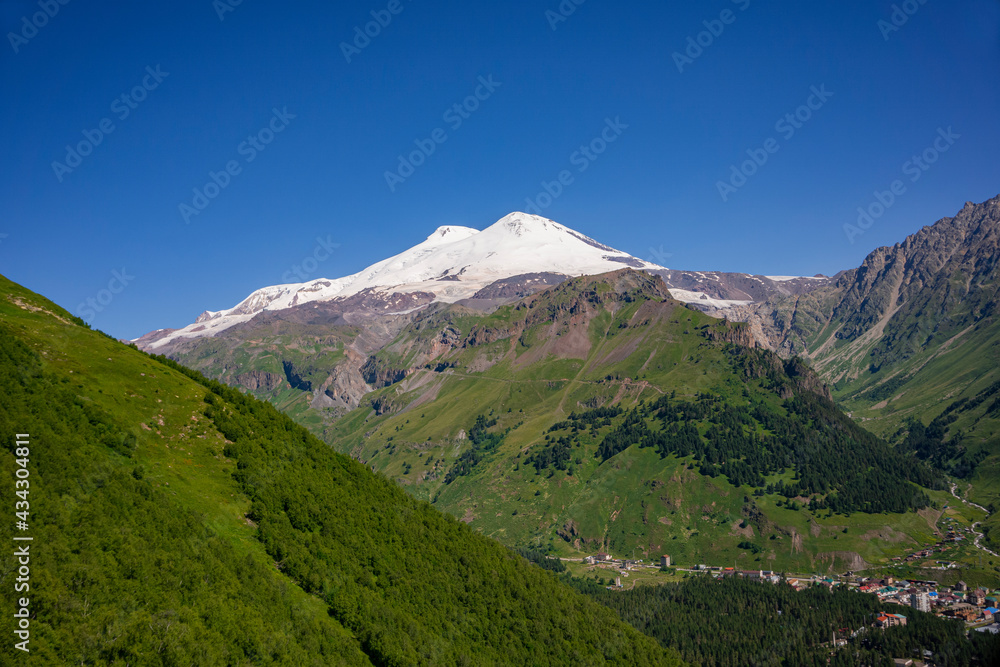 Mount Elbrus is a dormant volcano located in the south-east Caucasus mountain range in Kabardino-Balkaria, Russia. Viem from Cheget mount. July. Panoramic view from Cheget mount slope