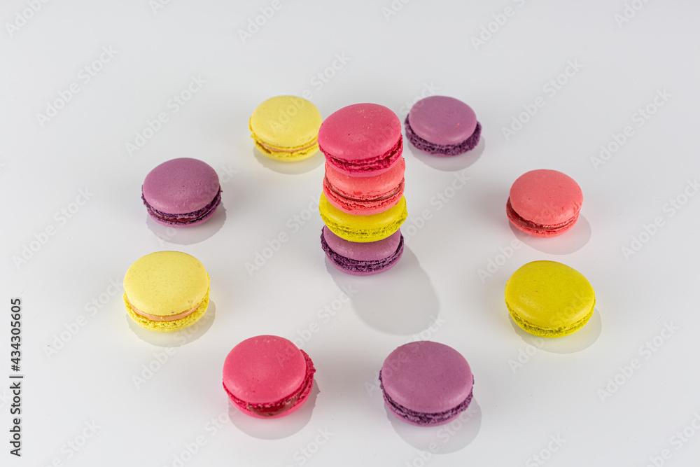 colorful macaroni cakes stacked in a tower and a circle on a white background colorful macaroni cakes stacked in a tower and a circle on a white background