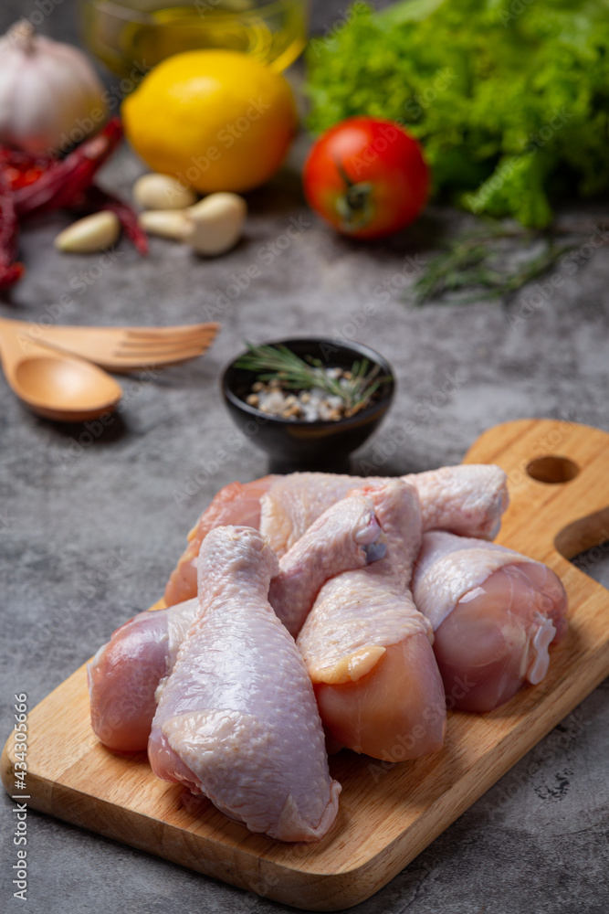 Raw uncooked chicken legs on the dark background. Raw uncooked chicken legs on the dark background.