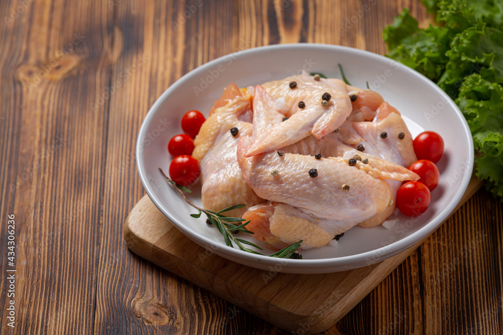 Raw chicken wings on the dark wooden background. Raw chicken wings on the dark wooden background.
