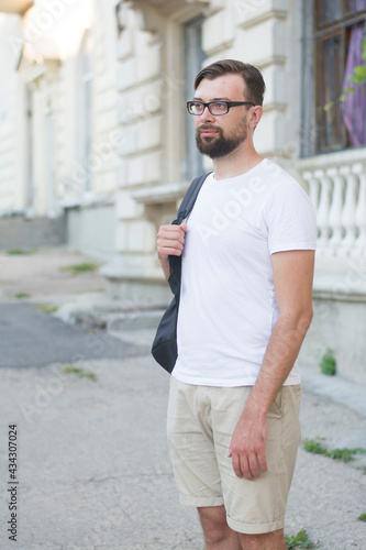 Young handsome man with beard wearing glasses and white t-shir