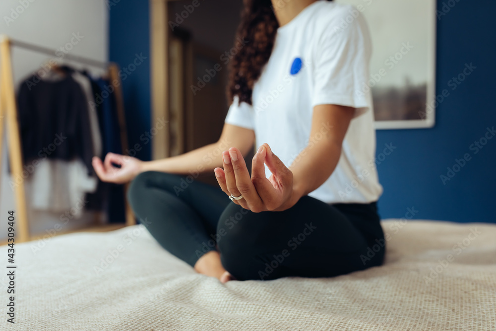 Frau macht Yoga und Dehnübungen zur Entspannung zuhause auf dem Bett
