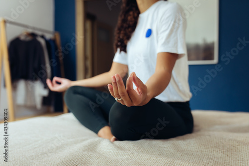 Frau macht Yoga und Dehnübungen zur Entspannung zuhause auf dem Bett