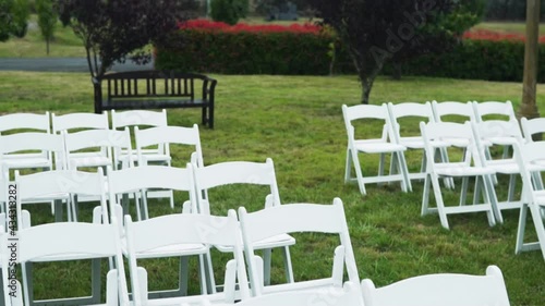 White Chairs arranged on the garden for the wedding. close up photo