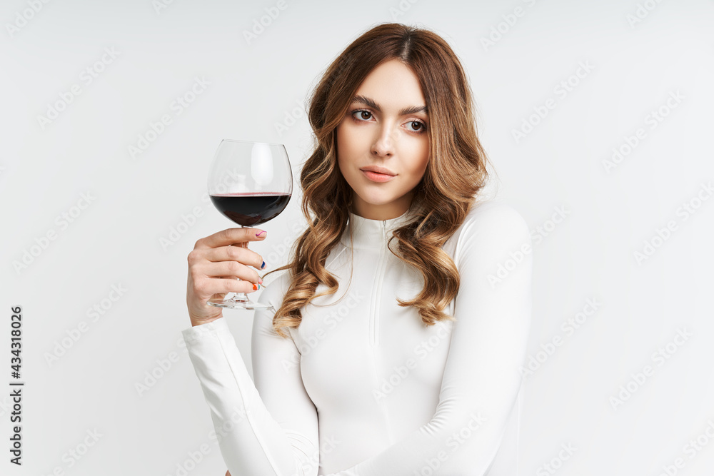 Pretty fashion woman holding glass of red wine on white background Pretty fashion woman holding glass of red wine on white background