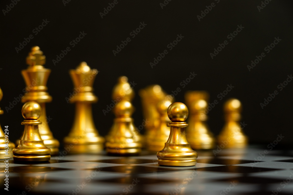 Gold pawn is on the first move in chess game on black background (Concept for business decision, start or beginning project) Gold pawn is on the first move in chess game on black background (Concept for business decision, start or beginning project)
