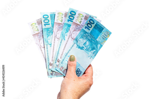 female hand holding one hundred and two hundred reais bills on isolated white background, concept of payment or government benefit photo