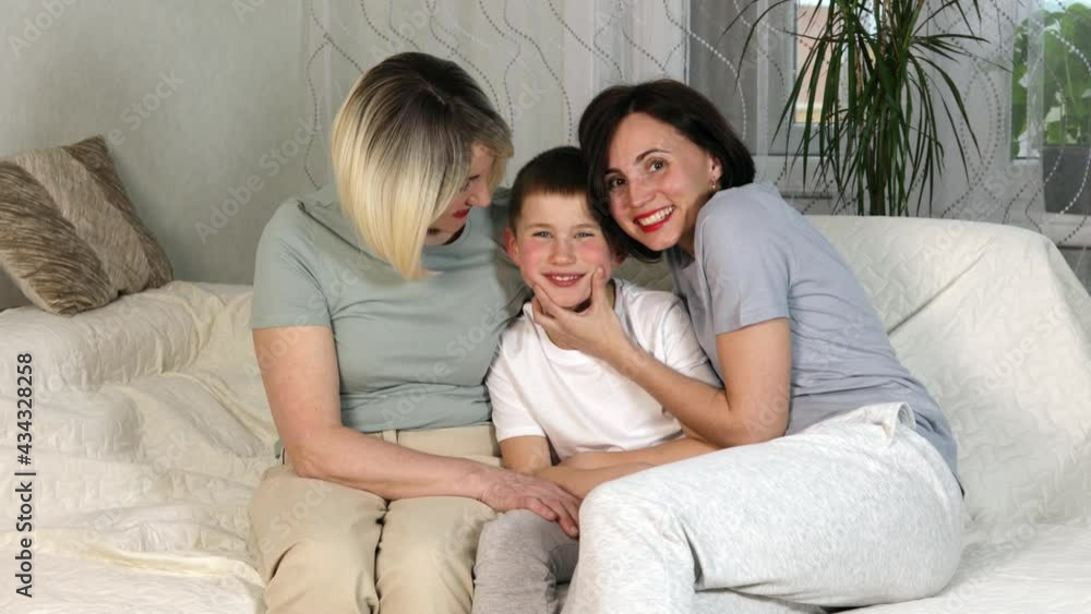 Happy smiling family, mother son and grandmother sitting on sofa in modern scandinavian apartment. White teeth. Family concept. Happy smiling family, mother son and grandmother sitting on sofa in modern scandinavian apartment. White teeth. Family concept.