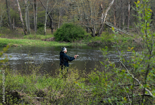 Man shore fishing in fresh water, during early spring