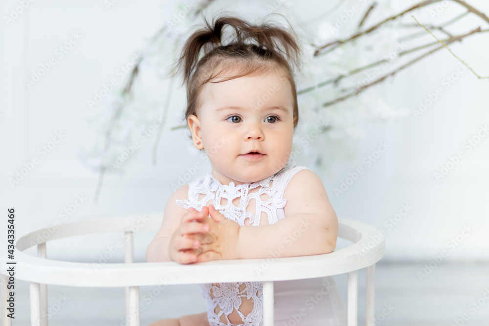 portrait of a baby girl in a white bodysuit on a light background portrait of a baby girl in a white bodysuit on a light background