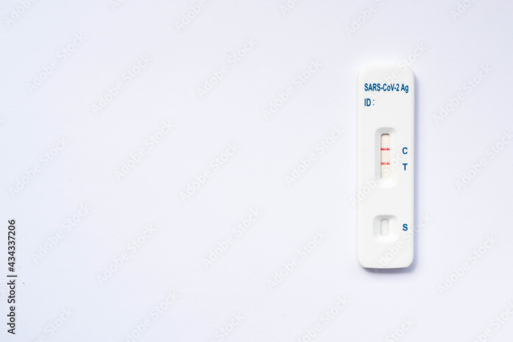 Positive rapid corona test on white background. Quick result of antigen sars-cov-2 test done by infected person. Copy space in the middle.