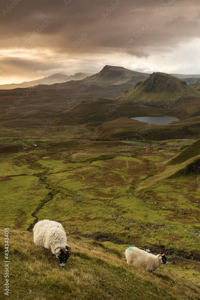 Obraz premium Scenic view of Quiraing mountains in Isle of Skye, Scottish highlands, United Kingdom. Sunrise time with colourful an rayini clouds in background.