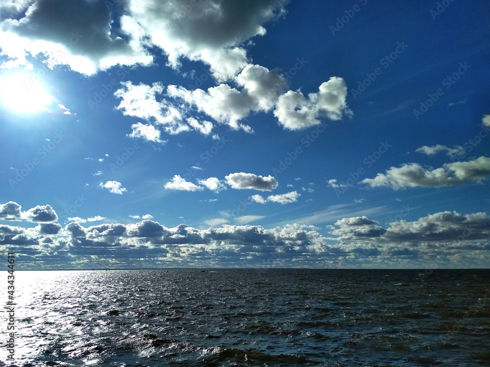 Obraz premium cloudy sky in the rays of the sun and the sea