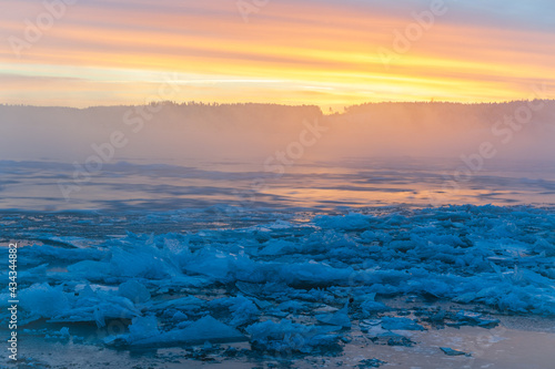 Colorful sunrise at icy river