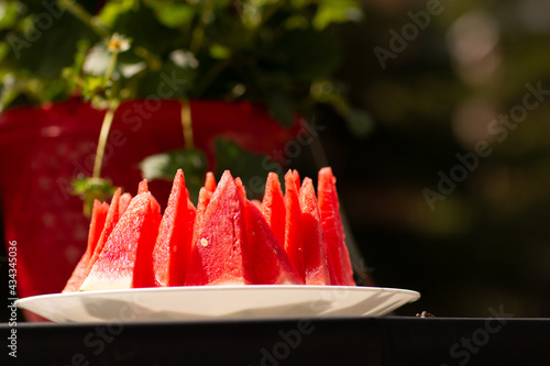 Juicy slices of bright red watermelon on a plate on a sunny summer day. photo