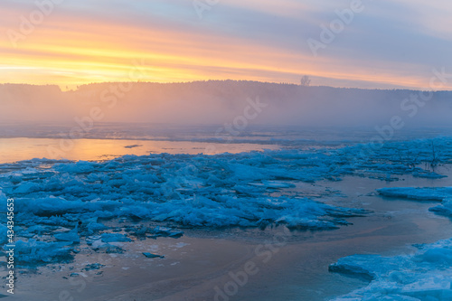 Colorful sunrise at icy river