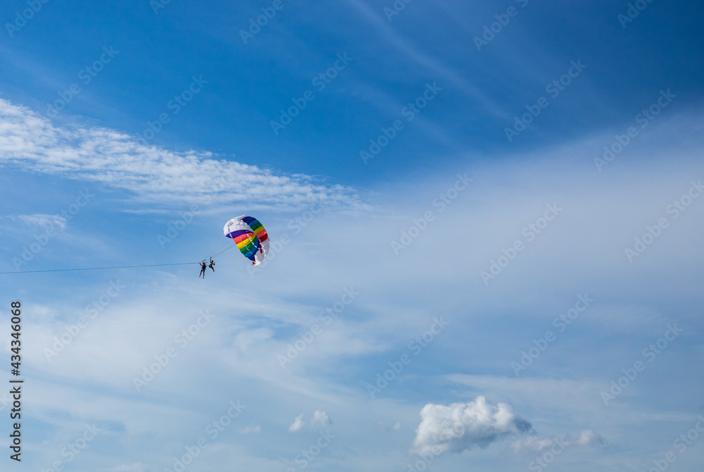 parachuye flight in fine weather against the background of a blue sky with small clouds