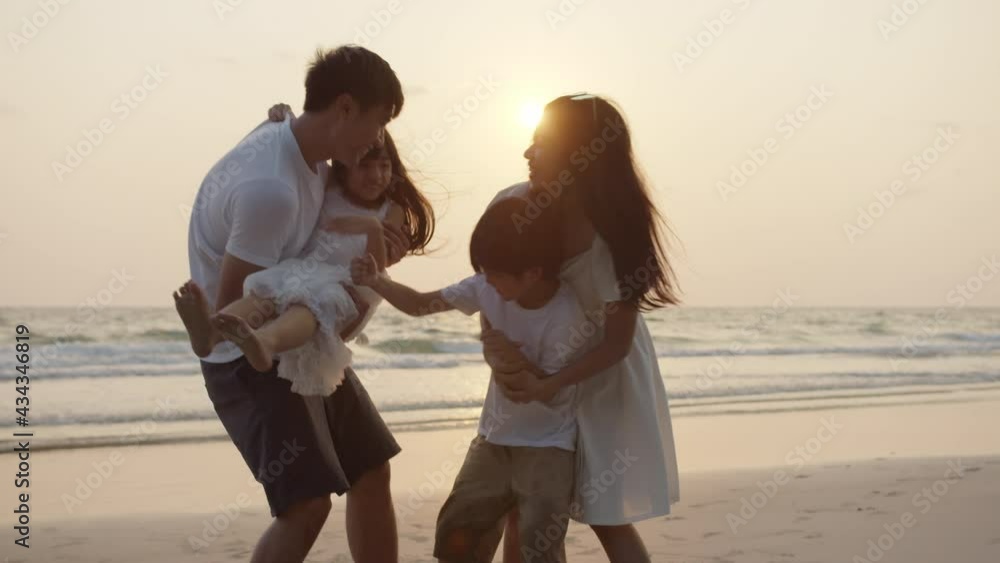 Silhouetted happy asian family playing and having fun on the beach at ...