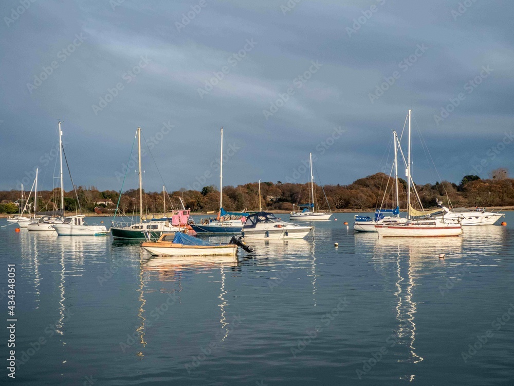 Obraz premium boats at anchor reflecting in the sea on a stormy spring day