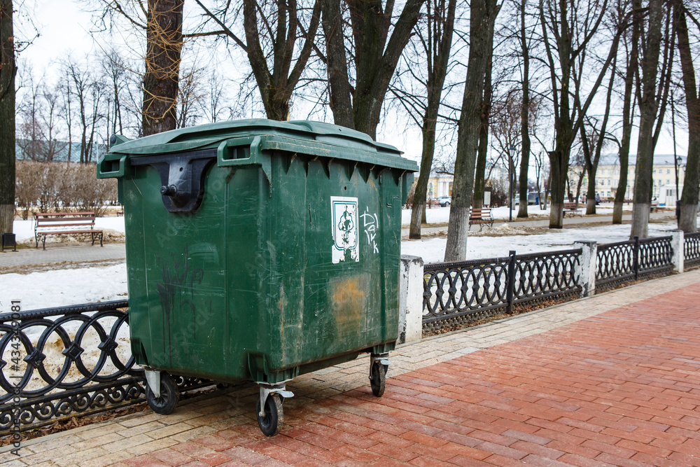 Green plastic garbage container in the street of Kostroma. Large dumpster for waste collection, recycling and utilization. Kostroma, Russian Federation Green plastic garbage container in the street of Kostroma. Large dumpster for waste collection, recycling and utilization. Kostroma, Russian Federation