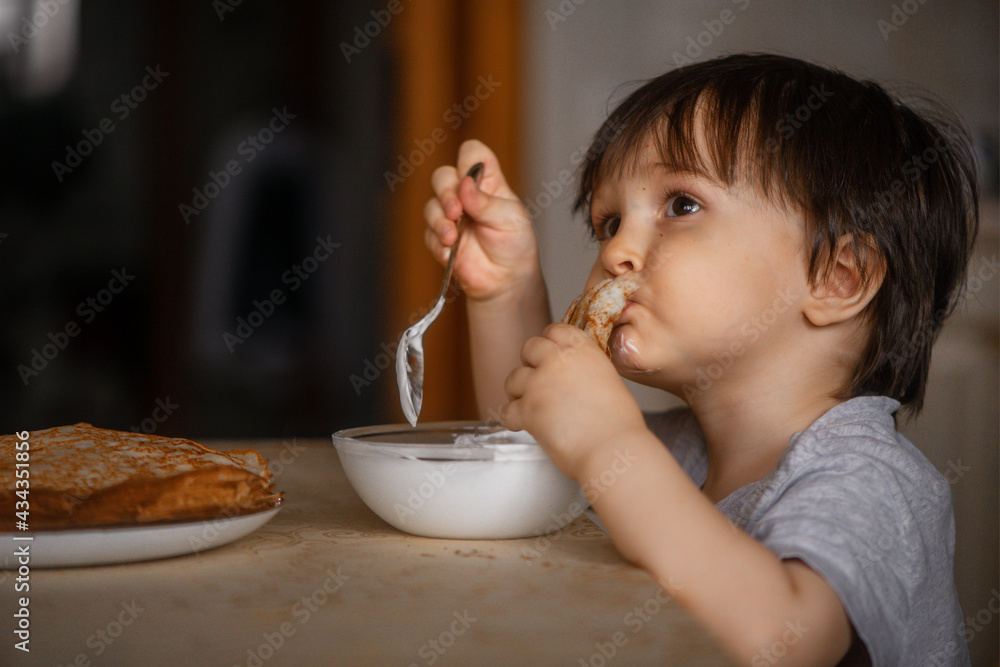 little boy eats pancakes with sour cream little boy eats pancakes with sour cream
