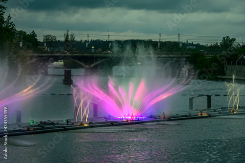 Evening view to Musical fountain with laser animations Roshen on the Southern Buh river in Vinnytsia, Ukraine. May 2021 photo