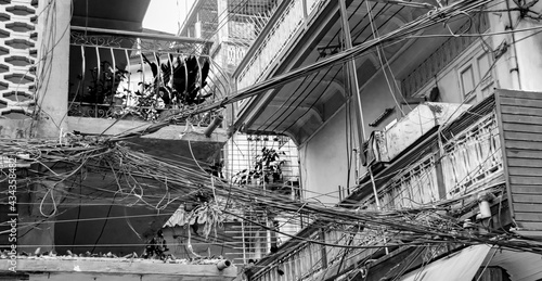 Cable chaos Thai power pole Bangkok Thailand black and white.
