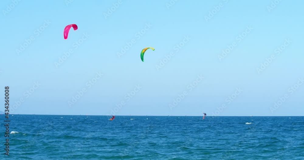 Summer vacation concept and extreme water sports. An athlete showing a sports trick is doing winter skiing, holding ski poles for his hands, jumping with a kite and a board. Concept sport, kitesurfer. Summer vacation concept and extreme water sports. An athlete showing a sports trick is doing winter skiing, holding ski poles for his hands, jumping with a kite and a board. Concept sport, kitesurfer.