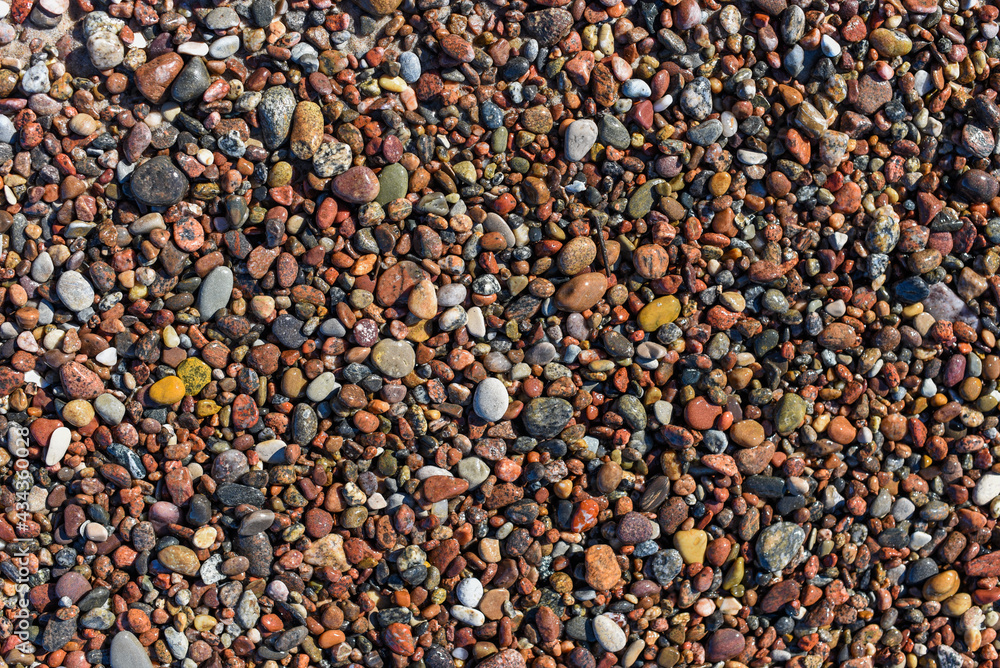 Texture of colorful pebbles lying on the beach on a sunny day. Texture of colorful pebbles lying on the beach on a sunny day.