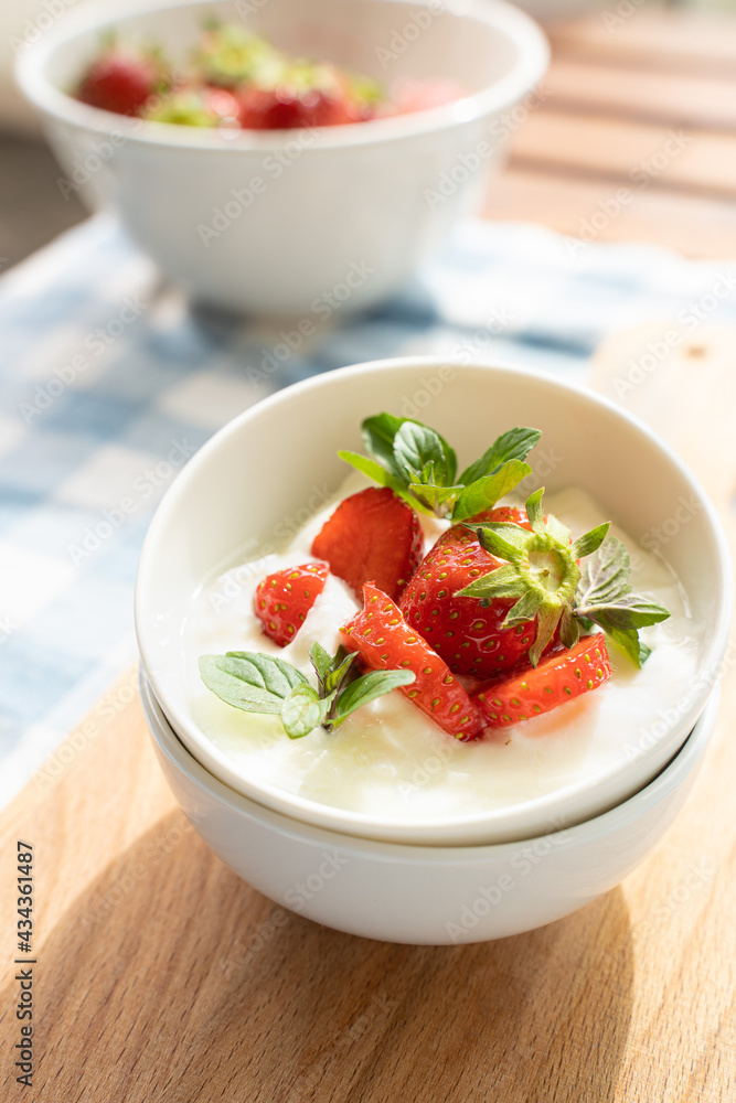 Yogurt with strawberry on the top in white plates Yogurt with strawberry on the top in white plates