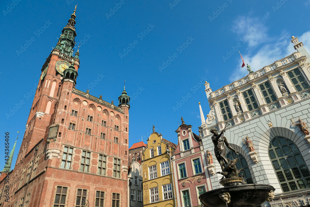 The Neptune's Fountain in Old Town of Gdansk, Poland. The fountain is located in the central point. Town Hall building in the back. City tour. Clear and bright day.