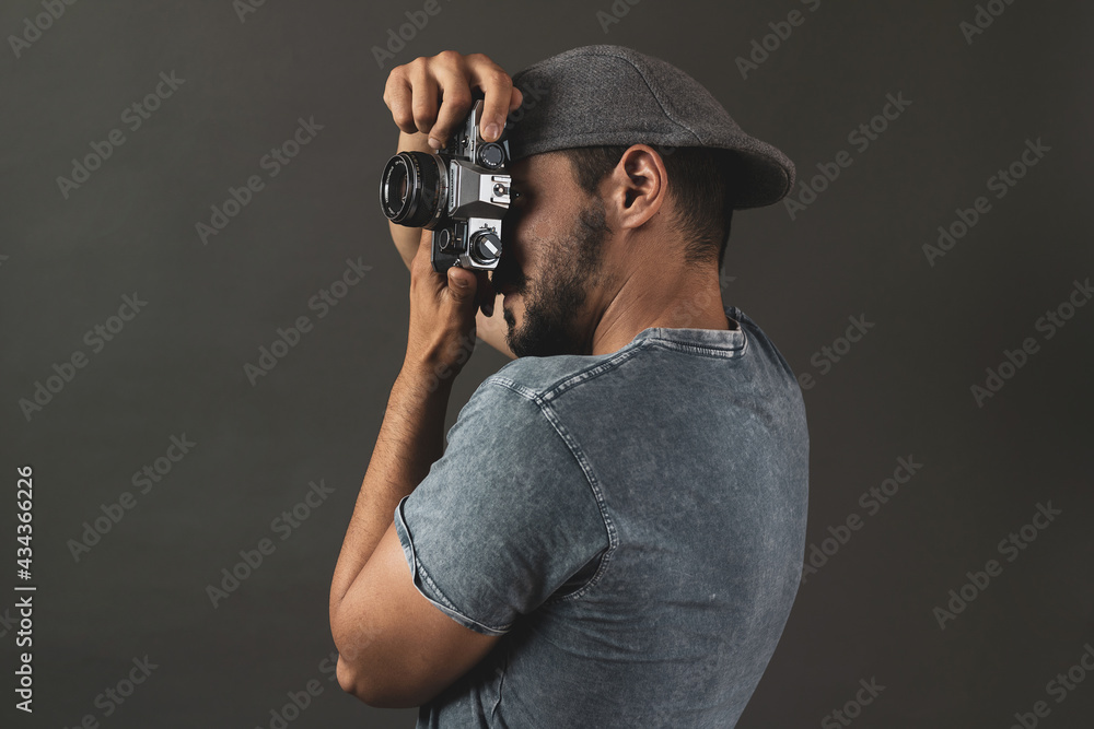 young man with classic clothes posing with a camera young man with classic clothes posing with a camera