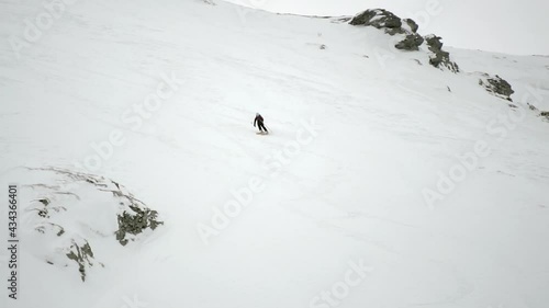 Slow motion of Freeride skier skiing downhill trough deep fresh powder. Extreme winter sport photo