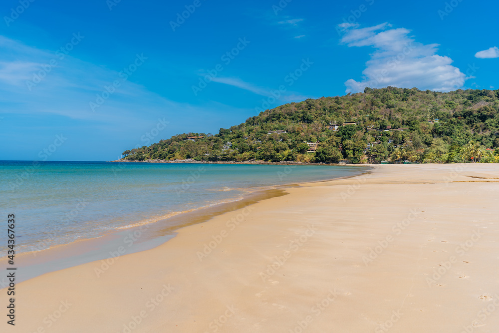 Idyllic tropical Karon beach with white sand, turquoise ocean water and blue sky at Phuket