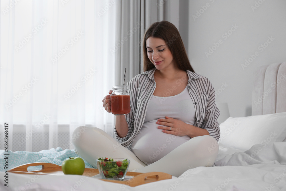 Pregnant woman eating breakfast on bed at home. Healthy diet Pregnant woman eating breakfast on bed at home. Healthy diet