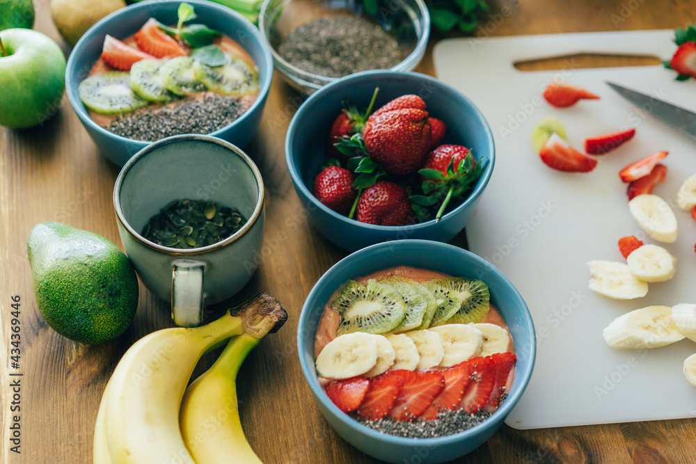 On the table are bowls of ready-made fruit smoothies, decorated with fruits. Cooking. On the table are bowls of ready-made fruit smoothies, decorated with fruits. Cooking.