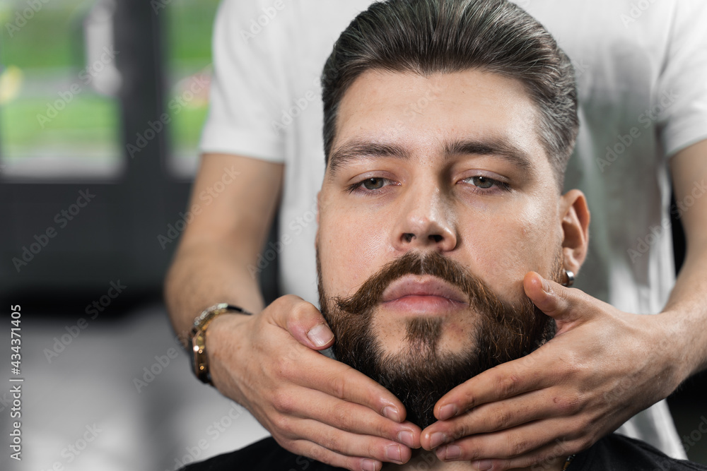 Obraz premium Fixing the shape of the beard with wax. The result of a haircut in a barbershop.